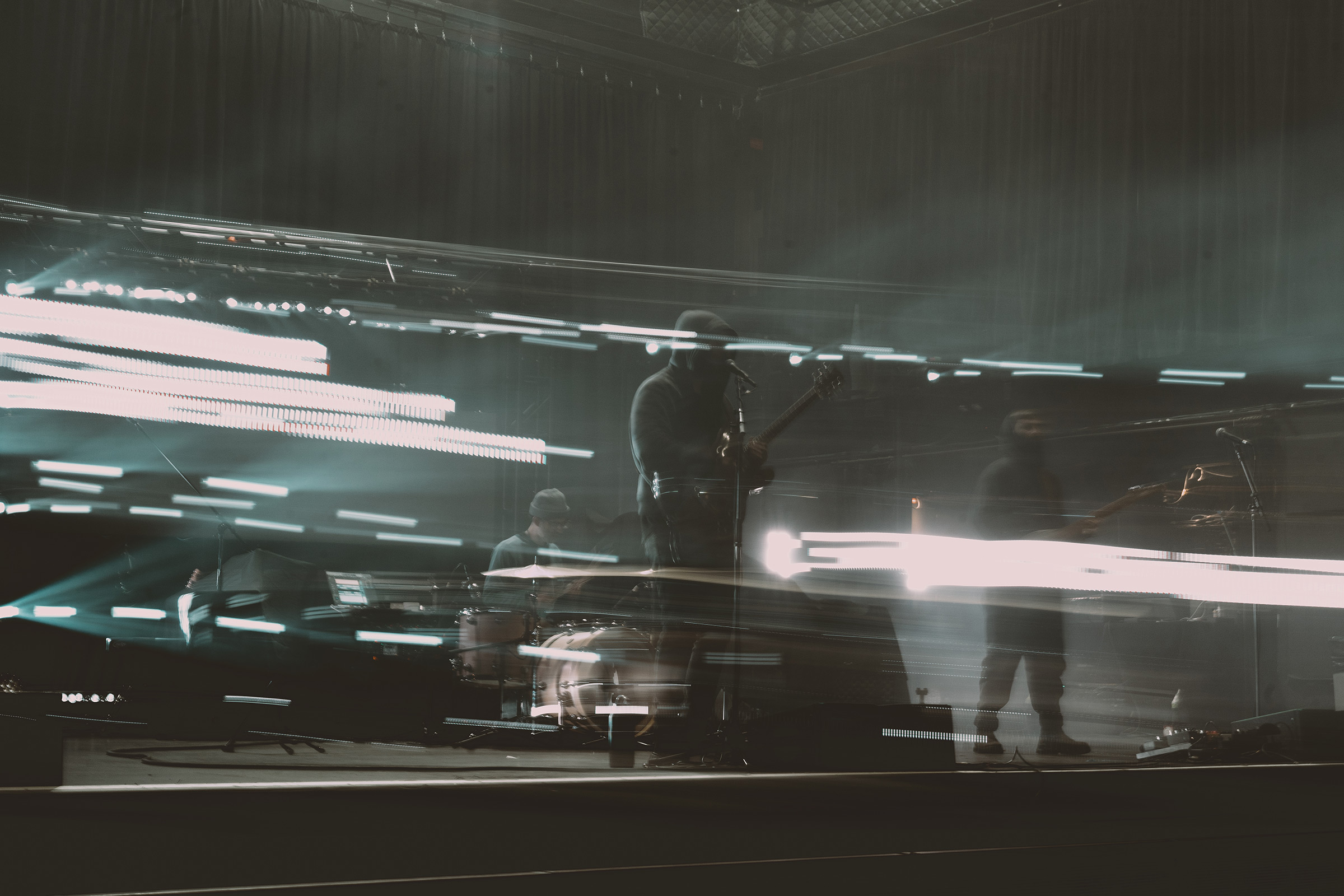 long exposure of slenderbodies on stage with dramatic light trails horizontal across the stage