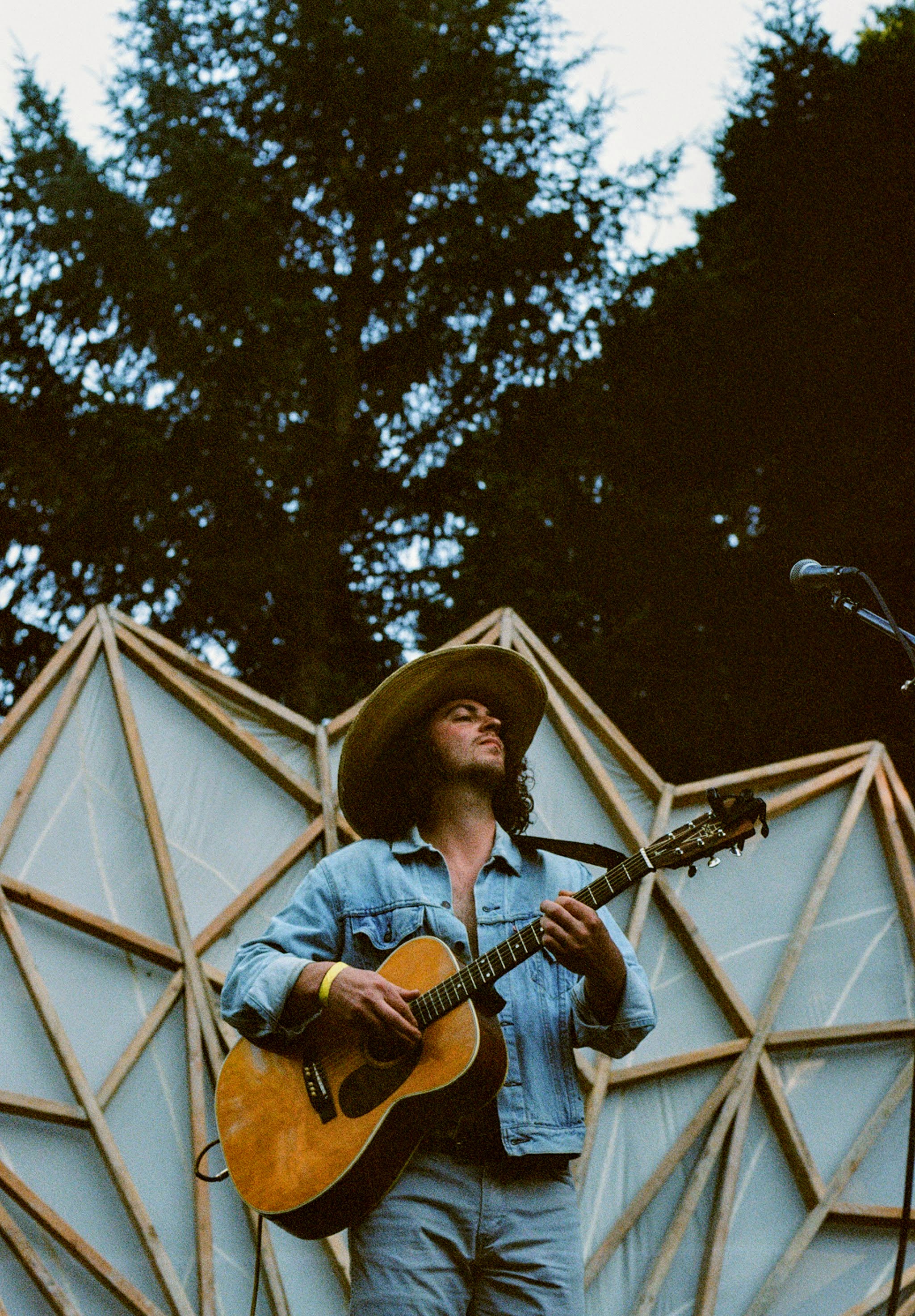 erik brock on a flowering white background stage with the woods behind. shot on film